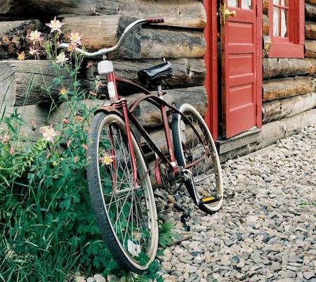 Townie bike leaned up against a historic cabin