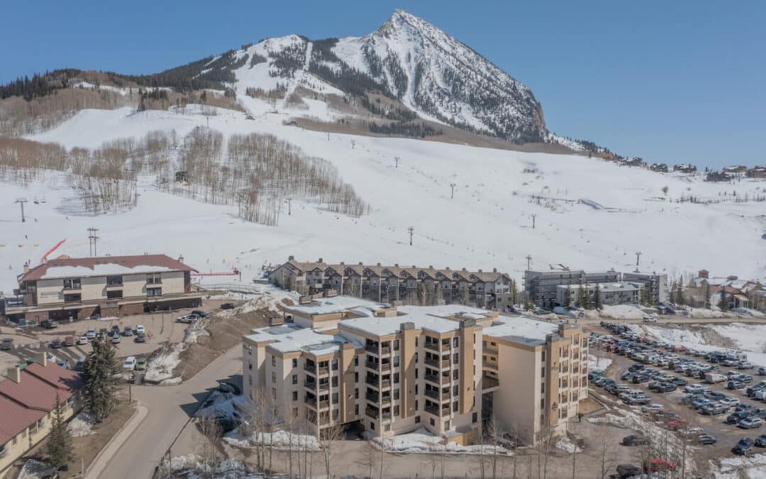 Crested Butte Real Estate - aerial image of the Plaza at Wood Creek condo building with Mt. Crested Butte in background.