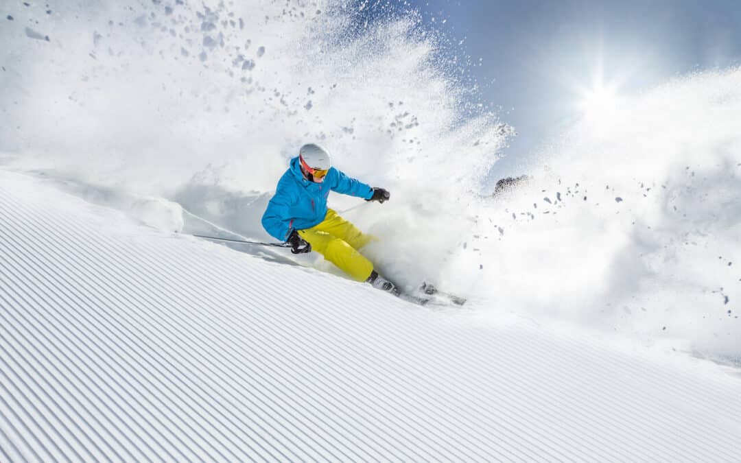 Winter skiing in Crested Butte - skier on groomed run, blue coat, yellow pants.