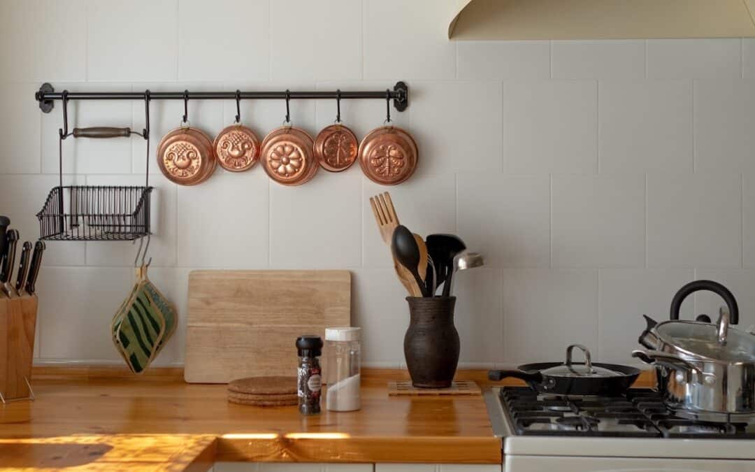 Crested Butte Real Estate - Easy Spring Cleaning Tips: Day 12 - copper pots & pans on a rack above kitchen counter.