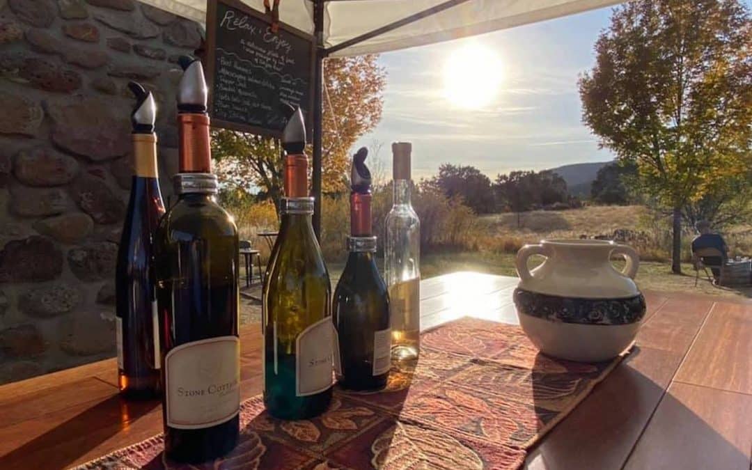 Crested Butte real estate - image of wine bottles on bar with sunset and fall leaves in background