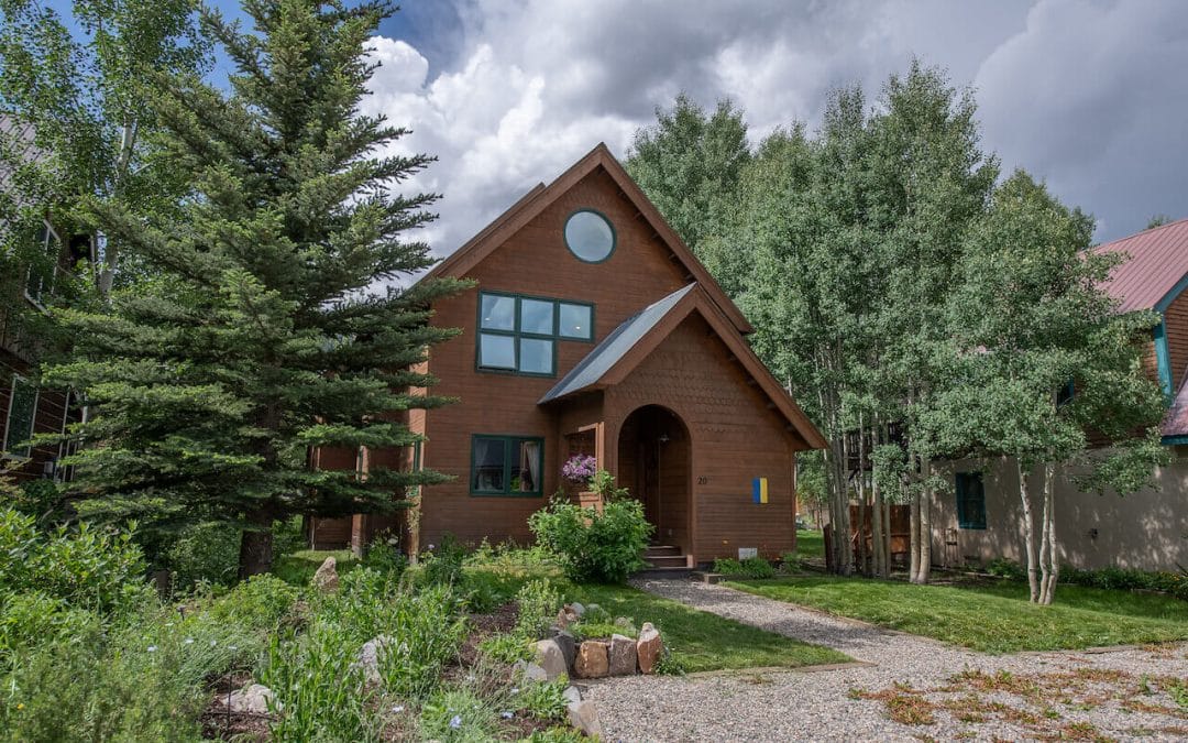 Crested Butte real estate - Back on the market, 20 Butte Avenue, Crested Butte (MLS 795794). Exterior photo. 2 story brown house surrounded by trees.