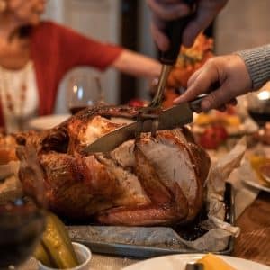 Crested Butte Events - Thanksgiving dinner table, man slicing turkey.