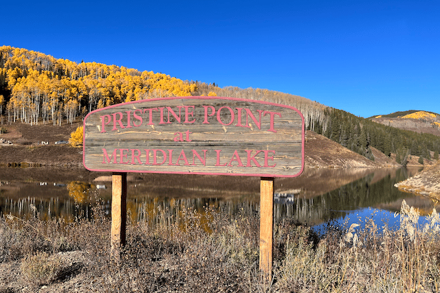 Crested Butte Real Estate - image of the sign at the Pristine Point subdivision. Lake, mountains and fall aspens in background.