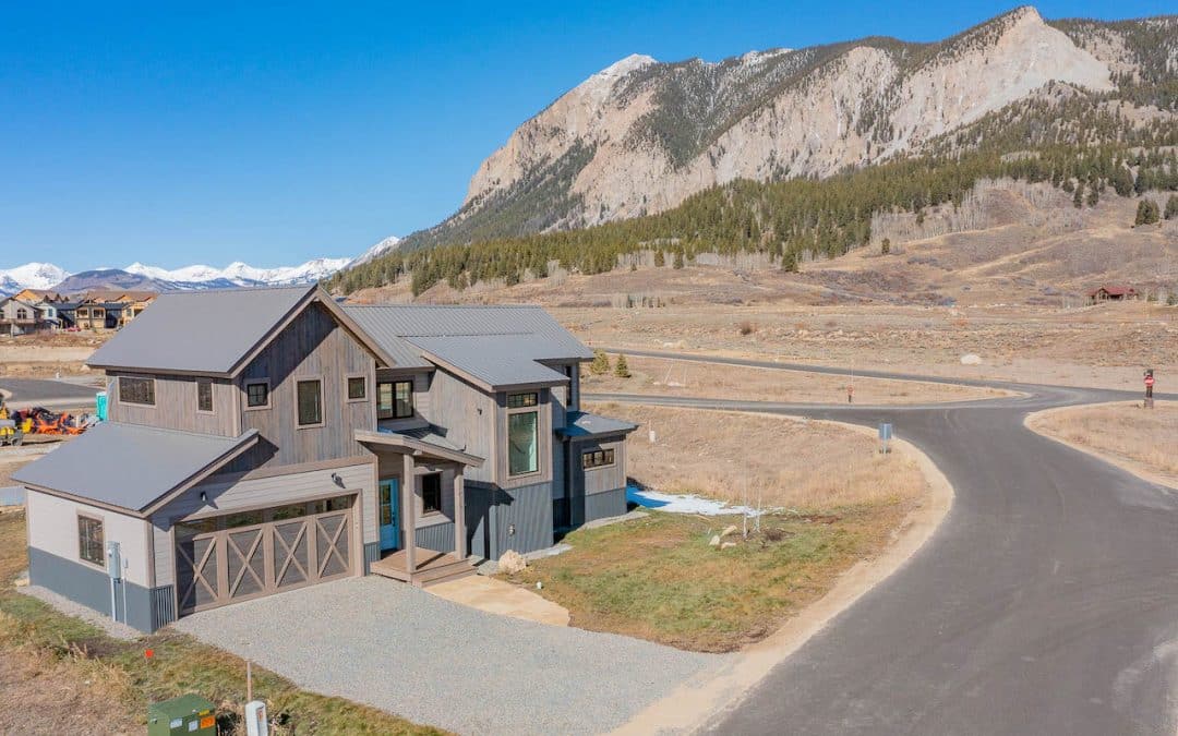 Crested Butte real estate - aerial image of 467 White Stallion Circle, Crested Butte (MLS 799529). Grey house two story house with Mt. Crested Butte in background.