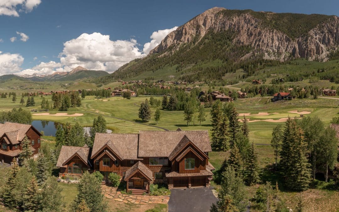 Crested Butte real estate is selling fast - aerial image of 29 Mulligan Drive - a two story luxury home on the golf course with Mt. Crested Butte in background.